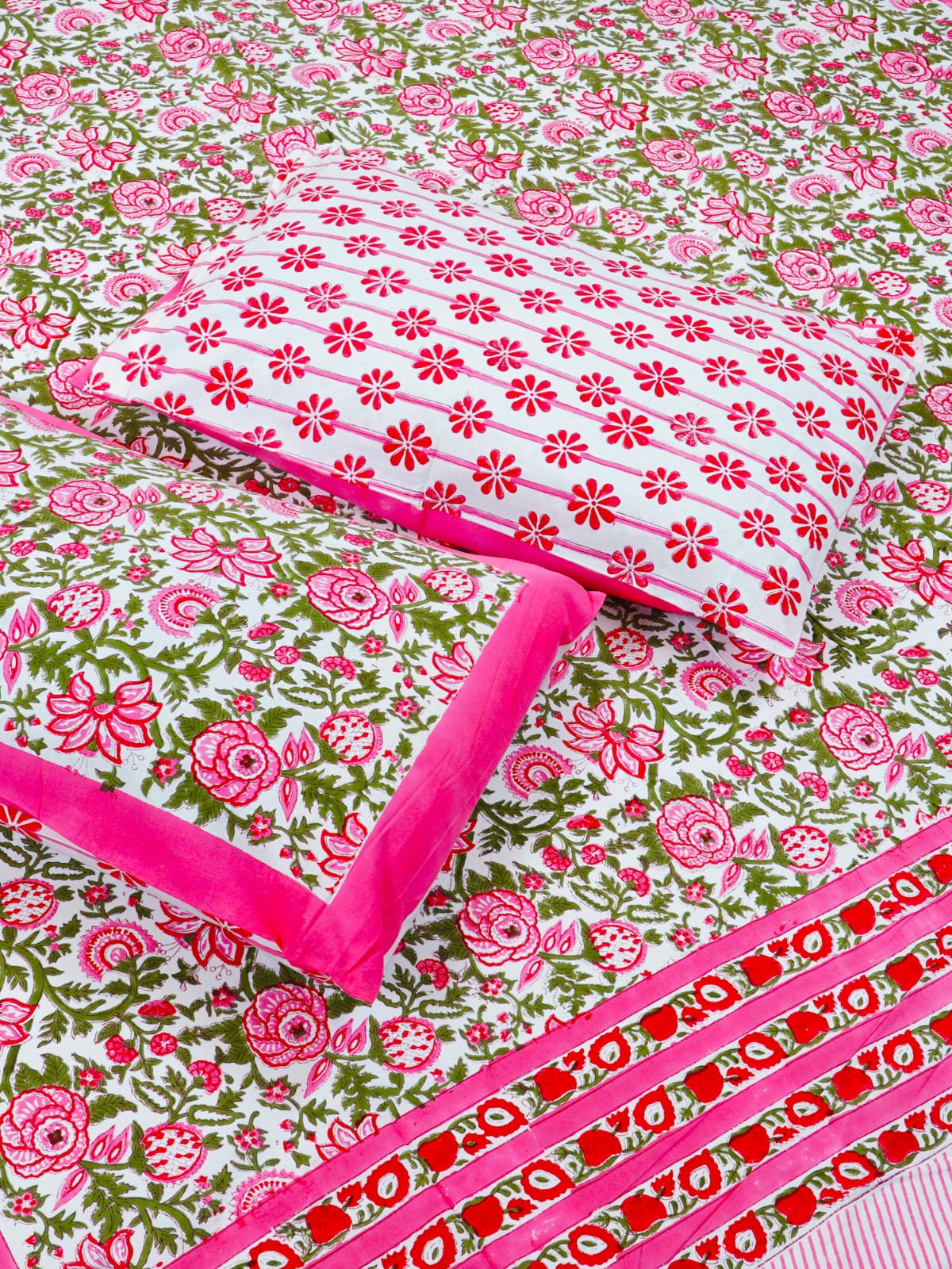 Floral fabric with pink and red patterns on a green background
